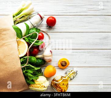 Sfondo di cibo sano. Cibo sano in un sacchetto di carta, verdure e frutta. Foto Stock