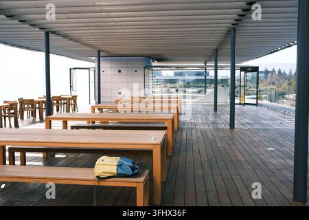 CUPERTINO, CALIFORNIA - 10 OTTOBRE 2024: Terrazza sul tetto vuota con lunghi tavoli di legno al Centro visitatori di Apple Park. Foto Stock
