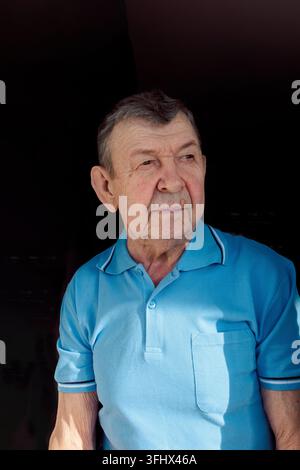 Ritratto di un uomo anziano su sfondo nero. Sguardo pensieroso del vecchio anziano. Primo piano del viso rugoso, spazio per la copia Foto Stock