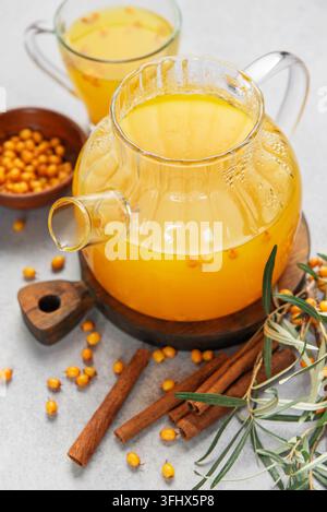 Tè di olivello spinoso in teiera con cannella e bacche Foto Stock