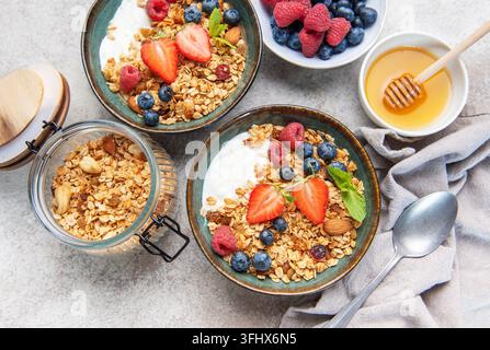 Ciotole di granola con frutti di bosco, yogurt, noci e miele per la colazione Foto Stock