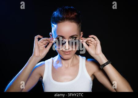 Ritratto ravvicinato di una donna dai capelli corti e alla moda che tiene le mani su un rotondo elegante Foto Stock