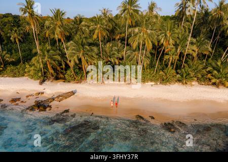 Passeggia lungo le coste incontaminate della spiaggia di Takhian a Koh Kood in Thailandia, dove la morbida sabbia bianca incontra le acque cristalline. Le palme oscillano dolcemente Foto Stock