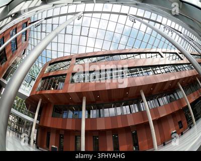 MARBURG, GERMANIA - 31 AGOSTO 2026: Vista a fisheye dell'interno moderno della biblioteca dell'Università di Marburg con un tetto di vetro drammatico, facciata rossa curva, un Foto Stock