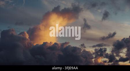 Nuvole di tempesta cupe e drammatiche che brillano al tramonto Foto Stock