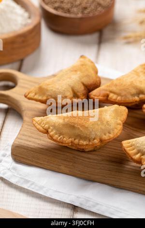 Mini pasticcini chebureki fritti su tavola di legno Foto Stock