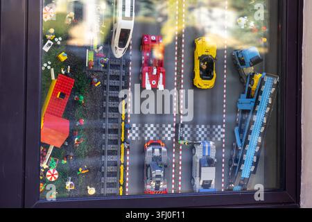 Szklarska Poręba, Polonia – 18 dicembre 2025: Blocchi di costruzione in miniatura colorati disposti come un circuito da corsa con modelli di veicoli per ispirare l'im Foto Stock