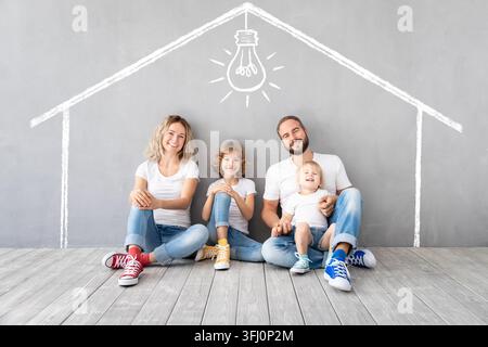 Famiglia felice con due bambini che giocano nella nuova casa Foto Stock