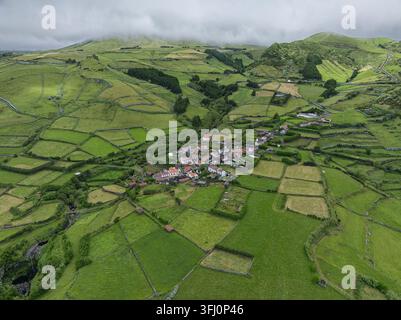 Vista aerea del villaggio di Faja Grande sull'isola di Flores circondato da campi verdeggianti e mura di pietra a Faja Grande, Azzorre, Portogallo. Foto Stock