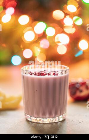 Frullato di melograno con ananas e decorazioni natalizie Foto Stock
