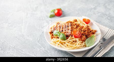 Pasta Spaghetti Bolognese in piatto bianco su sfondo grigio. La salsa Bolognese è un classico piatto della cucina italiana. Popolare italiano fo Foto Stock