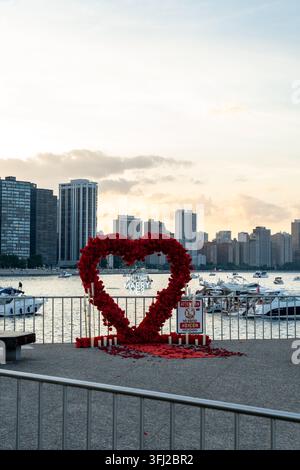 18 settembre 2026 - Chicago, Illinois, USA: cartello di proposta di matrimonio a forma di cuore rosso sul molo sul lungomare a Chicago durante il tramonto con il lago Michigan Foto Stock