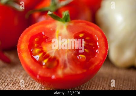 Mezza pomodoro rossa matura succosa con semi in primo piano Foto Stock