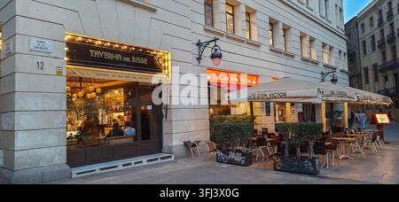 Comoda seduta all'aperto di caffè e taverna su un angolo di strada nel Quartiere Gotico di Barcellona - Barcellona, Spagna - 17 gennaio 2023 Foto Stock