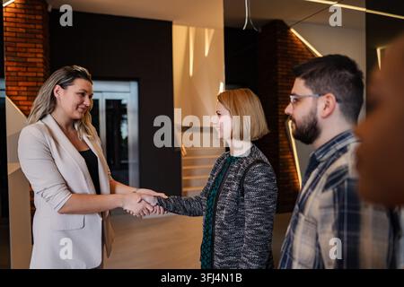 Donne d'affari che si stringono la mano dopo un incontro di lavoro di successo Foto Stock