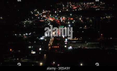 Ripresa aerea ampia di una scena notturna con traffico a un incrocio di periferia negli Stati Uniti. Fari bianchi lampeggianti e luci posteriori rosse. Virginia, Stati Uniti, Lyn Foto Stock
