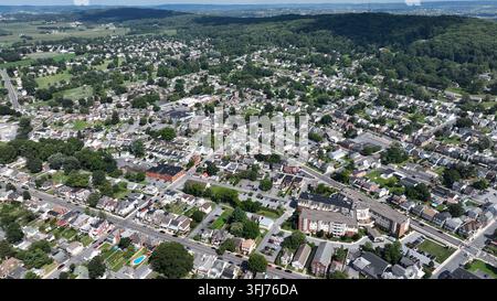 Ripresa aerea con droni ad angolo elevato di Ephrata City circondata da colline verdi ricoperte di vegetazione negli USA. Città storica e piscina nel giardino di una zona residenziale. Casa Foto Stock