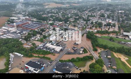 Città allagata in America dopo forti piogge notturne. Vista aerea dall'alto. Fango e acqua sporchi che scorrono attraverso strade e campi. Distrutto e danneggiato Foto Stock