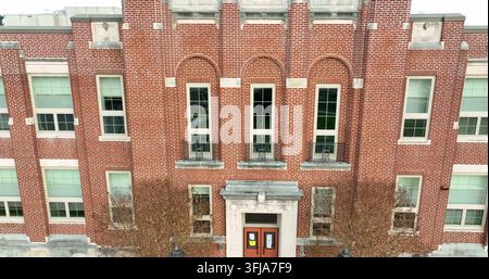Ripresa aerea ascendente di una scuola americana in mattoni rossi, edificio per uffici. Piano di stabilizzazione con drone durante una scena diurna fredda, Millersville, Pennsylvania. Foto Stock