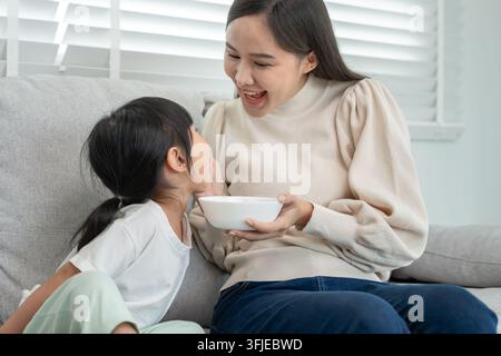 attività insieme durante le vacanze. Mamma e figlia stanno mangiando insieme, mamma prepara la colazione per la figlia la mattina, buon divertimento, settimana Foto Stock