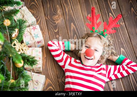 Bambino felice che indossa il renna Rudolph. Bambino divertente alla vigilia di Natale. Concetto di vacanza natalizia Foto Stock