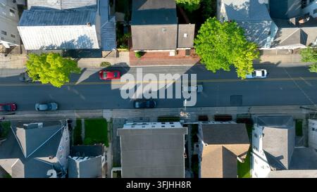 Veduta aerea dall'alto di un'auto che attraversa una città americana. Piccola città americana vista dall'alto con drone, vista a volo d'uccello, Manheim, Pennsylvania. Foto Stock
