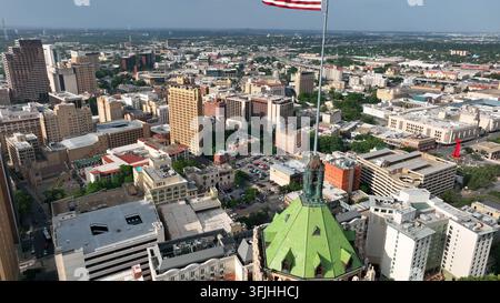 Centro di San Antonio in Texas con la bandiera americana degli Stati Uniti che sventola al vento. Salita aerea. Foto Stock