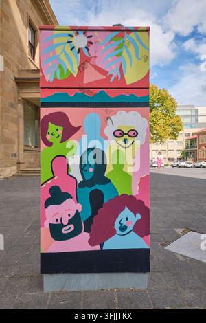 Gruppo colorato di personaggi divertenti in stile cartone animato. Una scatola elettrica utilitaria dipinta, parte di un progetto artistico comunitario nel centro di Hobart, Tasmania, Australia. Foto Stock