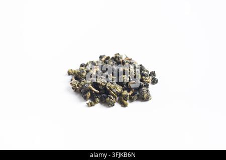 Primo piano di foglie di tè oolong di Taiwan essiccate e arrotolate ammucchiate, isolate su sfondo bianco con spazio per il testo Foto Stock