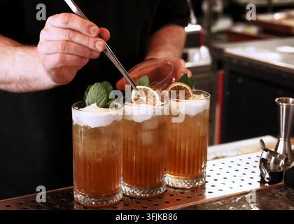 Barista che decora bevande alcoliche da cocktail Foto Stock