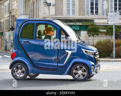 Donna alla guida di una mini auto elettrica a 2 posti 'senza patente' dell'IMF - Le Blanc, Indre (37), Francia. Foto Stock