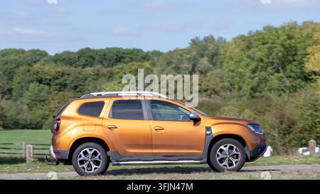 Milton Keynes; Regno Unito - 20 settembre 2026: auto Dacia Duster arancione del 2019 in corsa su una strada britannica Foto Stock
