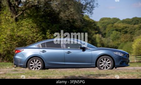 Milton Keynes; Regno Unito - 20 settembre 2026: Mazda 6 blu del 2013 in corsa su una strada britannica Foto Stock