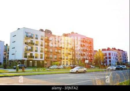 Edificio multi-appartamento con facciata vivace (gialla, mattoni e blu) in un complesso residenziale moderno. L'edificio residenziale si trova in una nuova zona residenziale Foto Stock