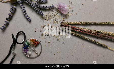 Un accattivante flat lay mostra una disposizione armoniosa di articoli di benessere spirituali e naturali, tra cui lavanda fragrante, un cristallo di ametista, arti Foto Stock