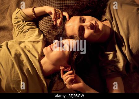 Ritratto di una coppia felice sdraiata insieme sul letto a casa Foto Stock