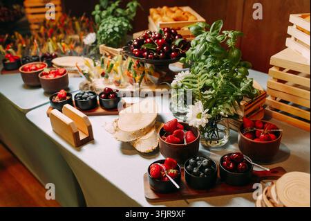 Elegante buffet di frutta con bacche fresche ed erbe a un evento catered Foto Stock