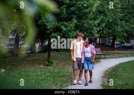 Giovani studenti universitari che camminano insieme nel parco vicino al campus del college. Foto Stock