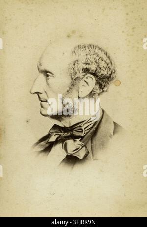 Fotografia raffigurante una Carte de visite di John Stuart Mill, di John & Charles Watkins (attività fotografica), dalla collezione di fotografie Carte de Visite, datata 1865. Un ritratto seppia di un uomo di profilo con capelli corti e ricci e basette pronunciate, che indossa una giacca scura e un grande papillon, su uno sfondo semplice e invecchiato con alcune macchie brunastre e toni crema e marrone chiaro. 10,6 (h) x 6,2 (l) cm, Ritratto, stampa fotografica. Iscrizione stampata sul recto: 'John & Charles Watkins, Phot. Copyright Secured.'. Iscrizione a inchiostro sul verso: 'John S. Mill MP 1/6'. Foto Stock