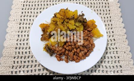 Piatto con un pasto tradizionale brasiliano di riso, fagioli, manioca e carne macinata Foto Stock