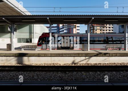 Gijon, Spagna – 19 settembre 2026 Un treno pendolare Renfe rosso e bianco aspetta su un binario vuoto sotto una tettoia metallica. Trasporto ferroviario regionale e Foto Stock