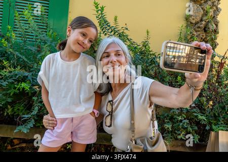 Nonna e nipote che si fanno un selfie insieme all'aperto Foto Stock