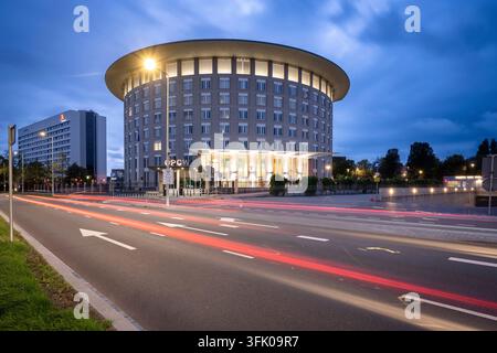 Il quartier generale dell'Organizzazione per la Proibizione delle Armi Chimiche (OPCW) su Johan de Wittlaan, con scie di luce del traffico stradale a mezzanotte Foto Stock
