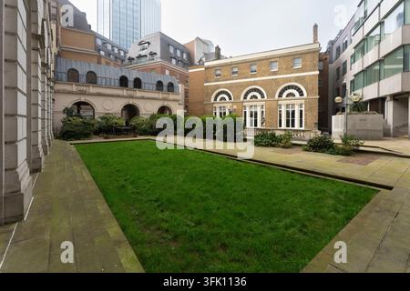 Un cortile verde tranquillo ad Adam's Court, Città di Londra, che offre una fuga urbana serena tra Threadneedle e Old Broad St. Foto Stock