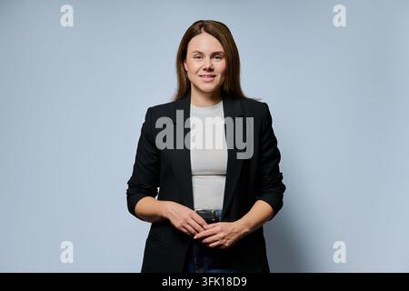 Donna d'affari sicura di sé in giacca nera, ritratto in studio Foto Stock