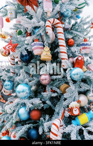 Albero di Natale ricoperto di ghiaccio decorato con caramelle e ornamenti Foto Stock