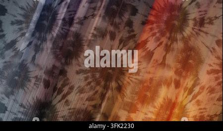 Uno scatto dettagliato di un tessuto tie-dye con una tavolozza di colori scuri e atmosferici che si trasforma in riflessi caldi, creando un aspetto ricco e textureato. Foto Stock