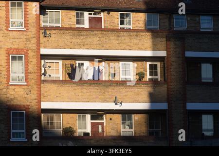Il bucato dei residenti si asciuga su un balcone all'Arden House su Black Prince Road a Vauxhall, Londra, catturando una tranquilla scena domestica quotidiana. Foto Stock