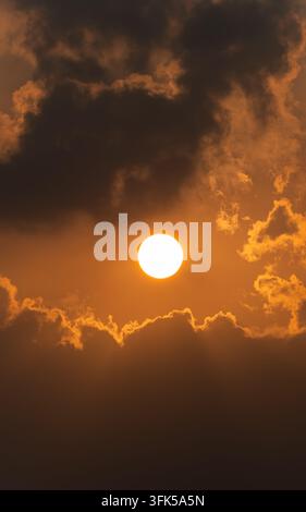 Scatto verticale del tramonto che si staglia su nuvole dai bordi dorati Foto Stock