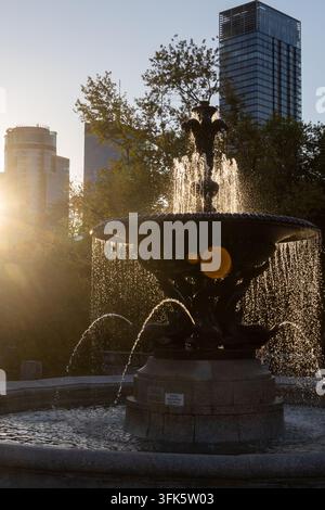 Fontana in città, illuminata dal sole che tramonta Foto Stock